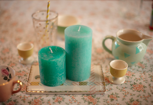 Bougies turquoises posées sur une plaque en verre