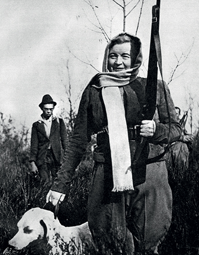 Rachele Mussolini, femme du dictateur Mussolini, tenant un chien et une arme en mains. 
