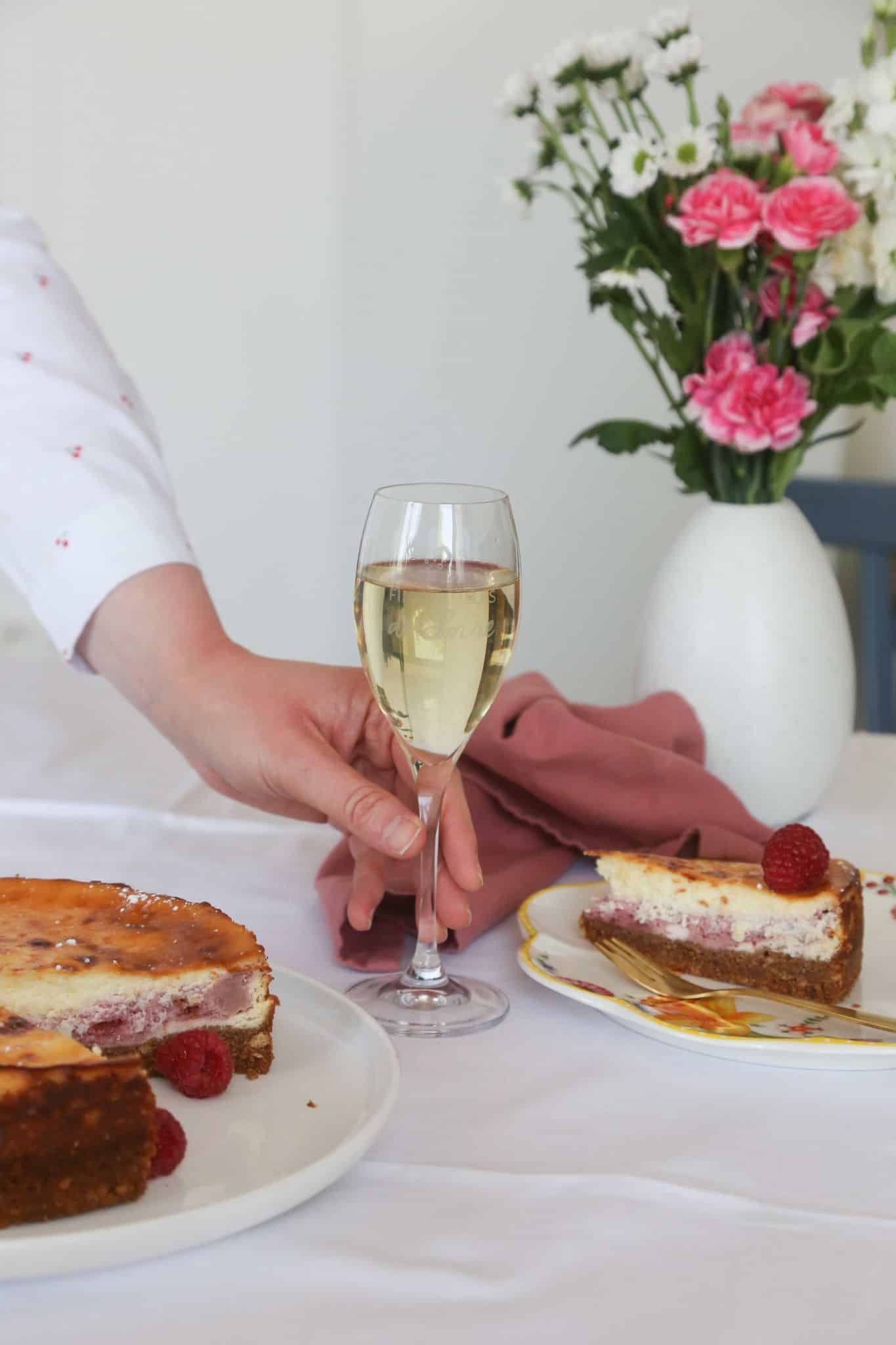 Cheesecake avec une main déposant un verre de vin blanc