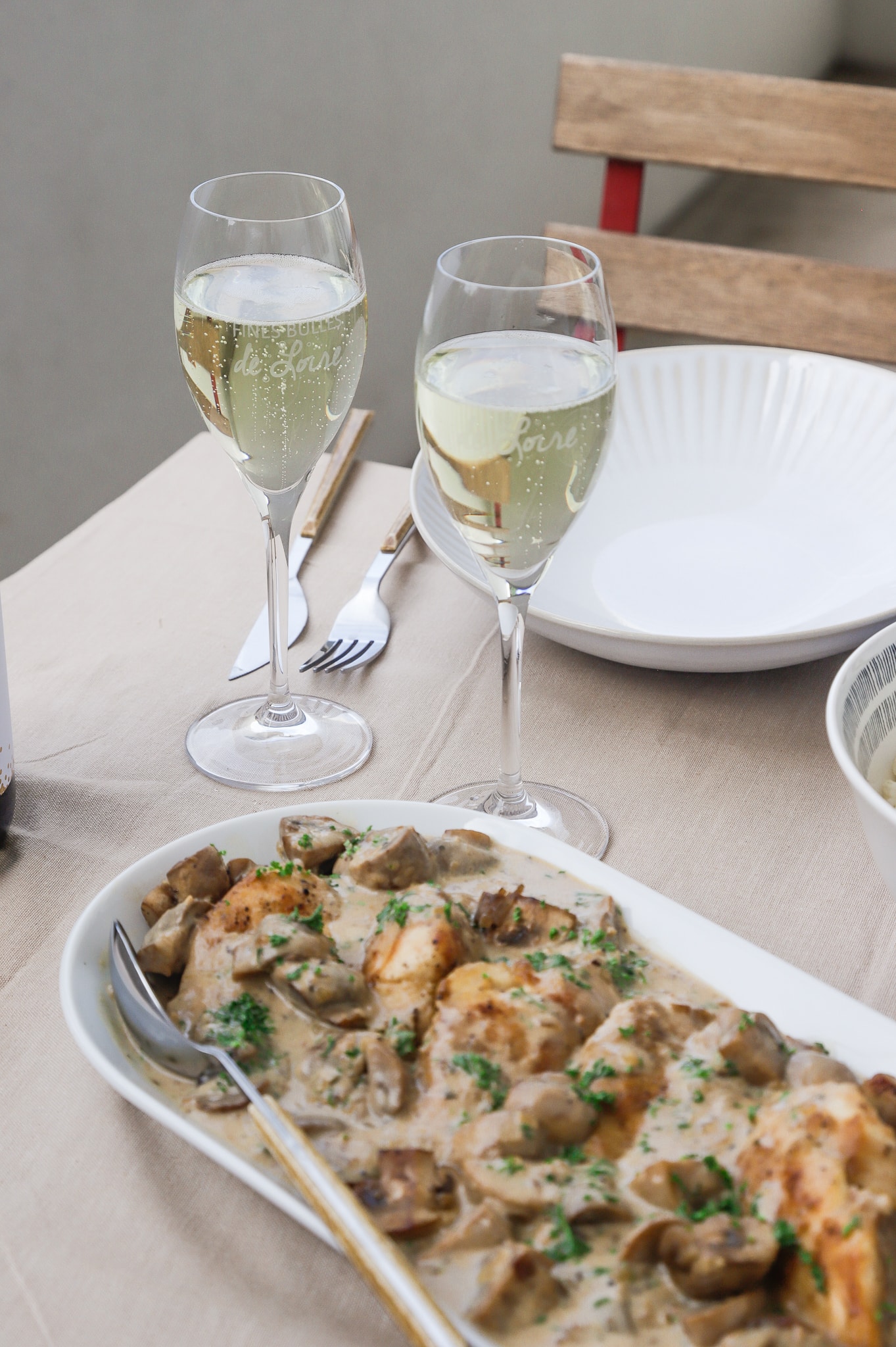 Plat de volaille en sauce et verre de vin blanc