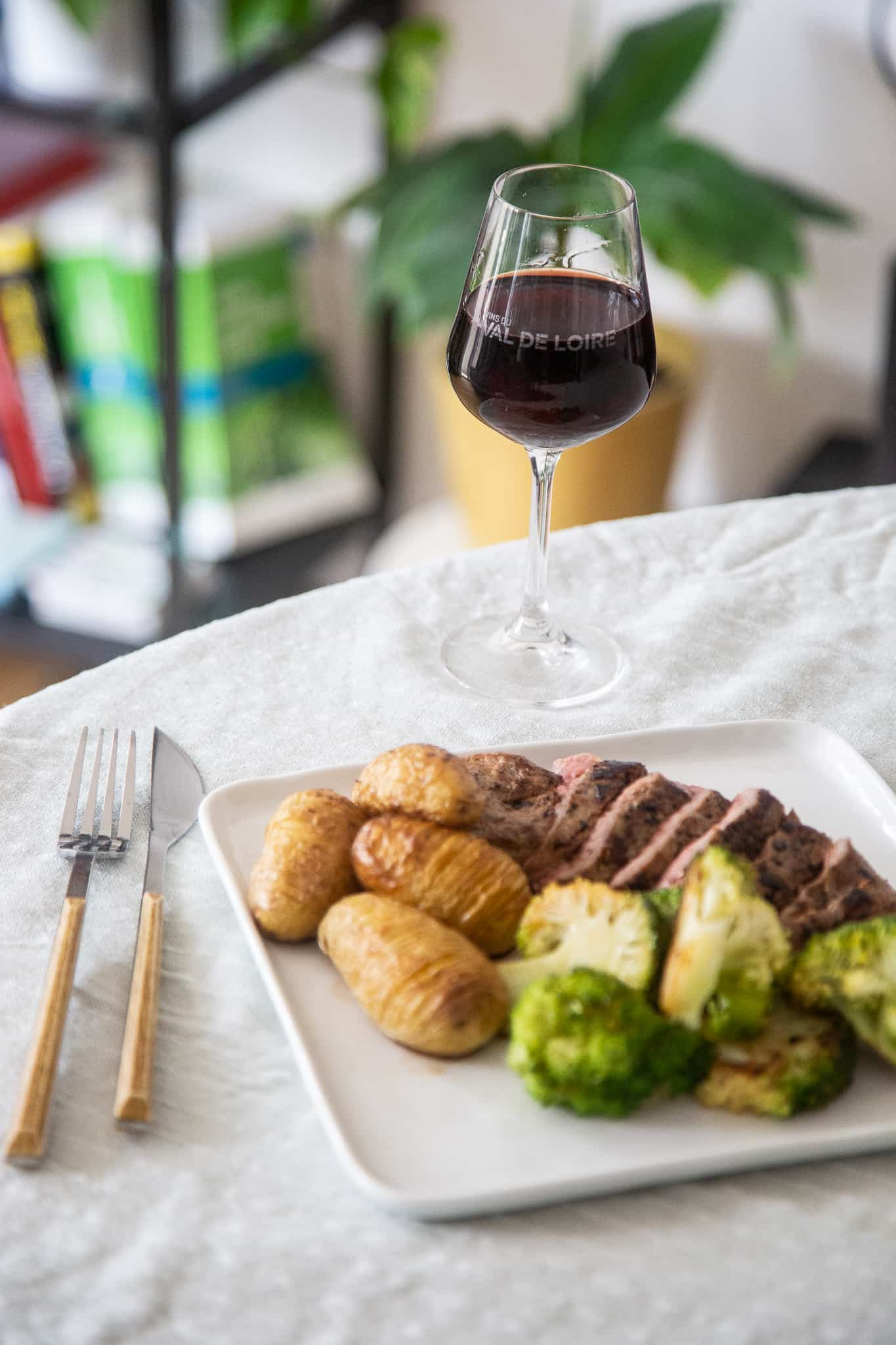 plat de gibier avec pommes de terre et choux de bruxelles et un verre de vin rouge