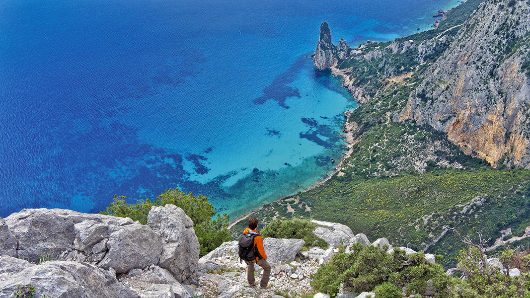 Photo aérienne d'une personne regardant la vue panoramique lors d'une randonnée en Sardaigne.