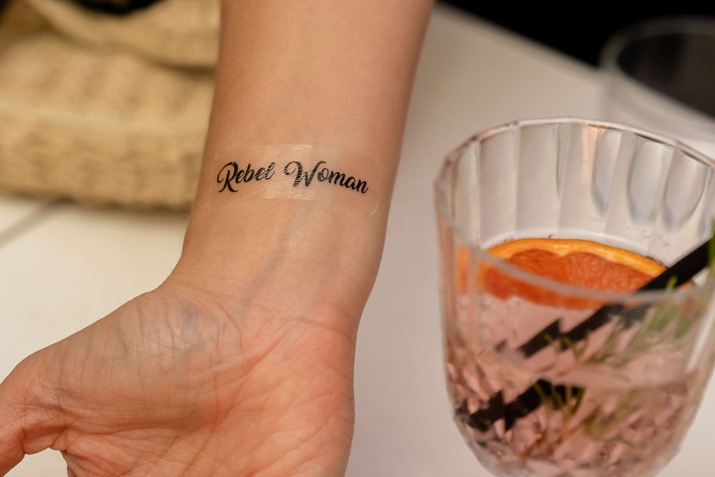 Faux tatouage au poignet écrit "Rebel Woman"